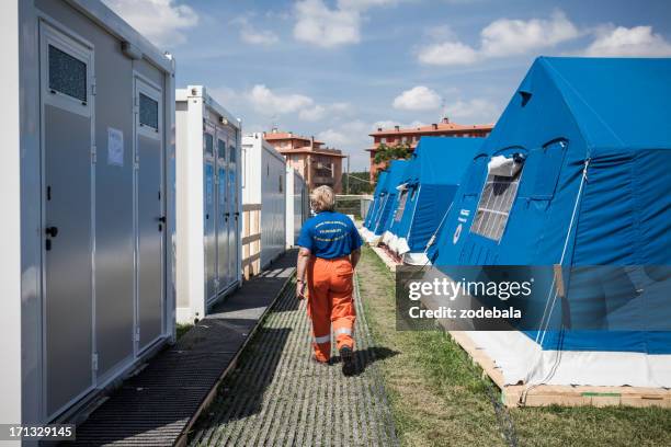 volunteer walking at refugee camp after italian eartquake of 2012 - wind shelter stock pictures, royalty-free photos & images