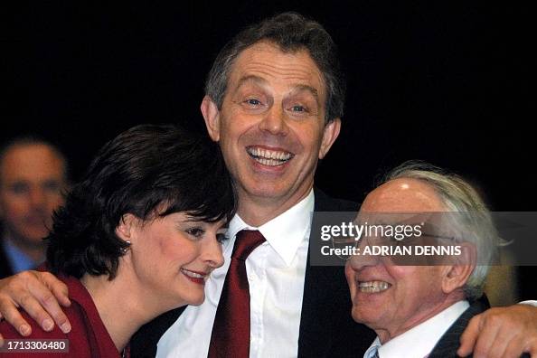 Britain's Prime Minister Tony Blair hugs his wife Cherie and father