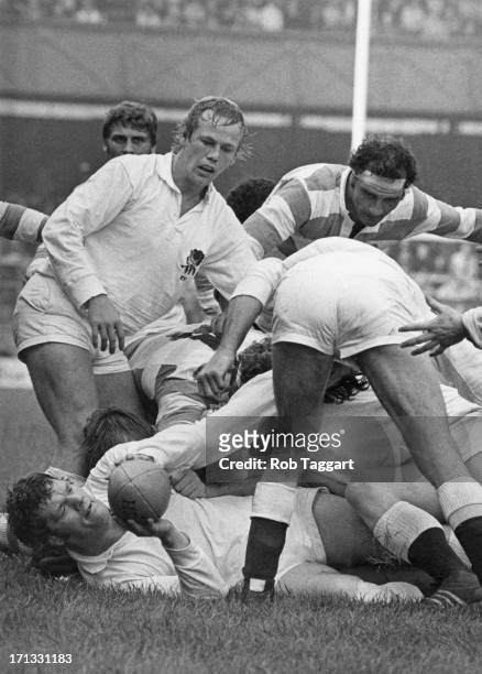 England prop Fran Cotton on the ground with the ball and England hooker Peter Wheeler above him in a maul during a match against Argentina at...