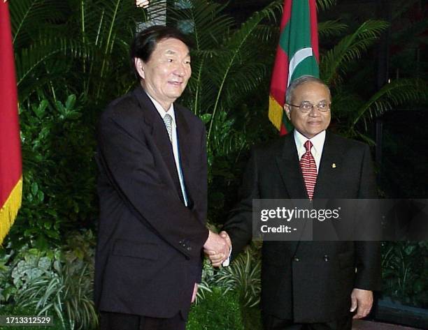 Chinese Premier Zhu Rongji shakes hands with Maldives President Maumoon Abdul Gayoom 16 May 2001 at a banquet dinner in Male at the start of a...