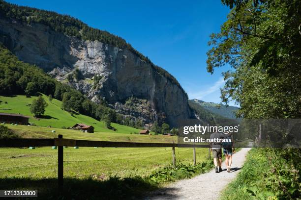 couple explore the beautiful town of lauterbrunnen in switzerland - staubbach falls stock pictures, royalty-free photos & images