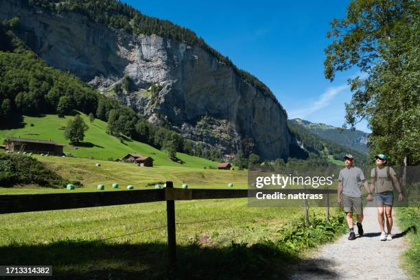 couple explore the beautiful town of lauterbrunnen in switzerland - staubbach falls stock pictures, royalty-free photos & images