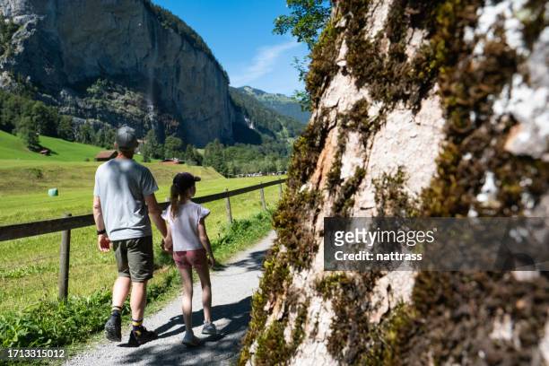 father exploring a beautiful town while on vacation in europe with his daughter - staubbach falls stock pictures, royalty-free photos & images
