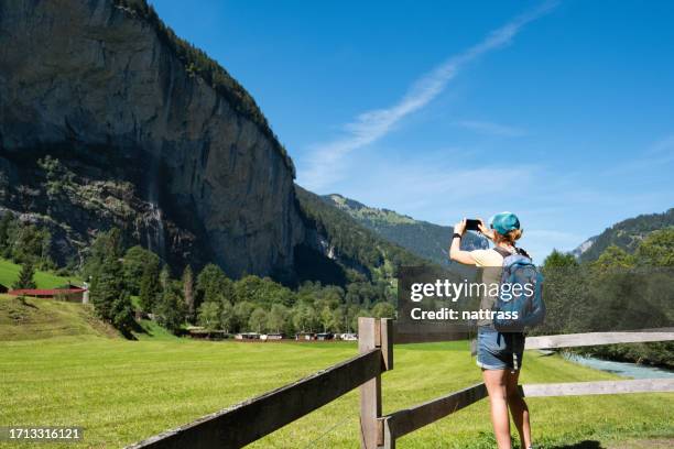 woman exploring the beautiful town of lauterbrunnen in switzerland - staubbach falls stock pictures, royalty-free photos & images