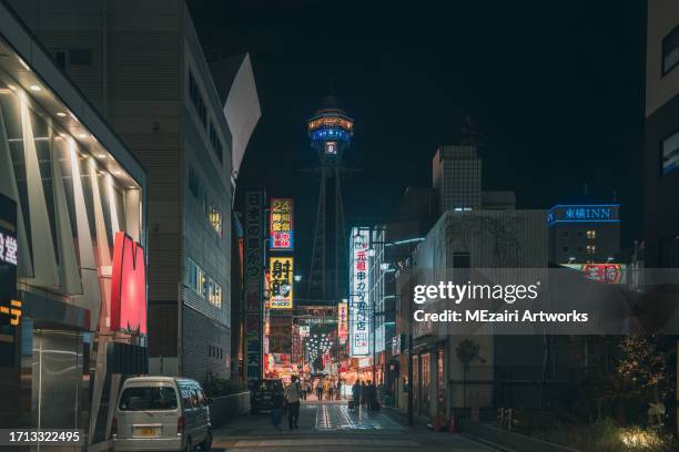 night scene at shinsekai district in osaka japan. the district is famous with street food stall, overlooking famous osaka tower tsutenkaku. - osaka shinsekai food stock-fotos und bilder