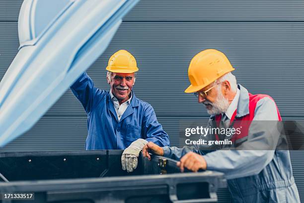 two manual emptying dustbin - smiling garbage collector stock pictures, royalty-free photos & images