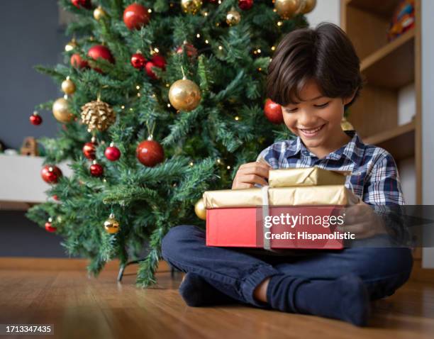 happy boy opening his present on christmas day - open day 8 stock pictures, royalty-free photos & images