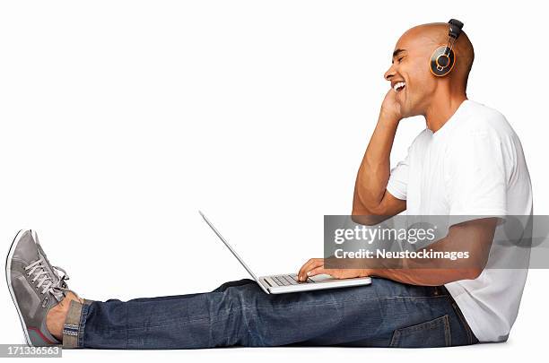 man enjoying music while using laptop - isolated - headphones isolated stock pictures, royalty-free photos & images