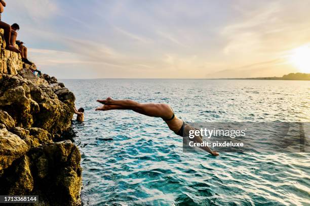 junge erwachsene frau taucht in das warme wasser der côte d'azur in südfrankreich. - region provence alpes côte dazur stock-fotos und bilder