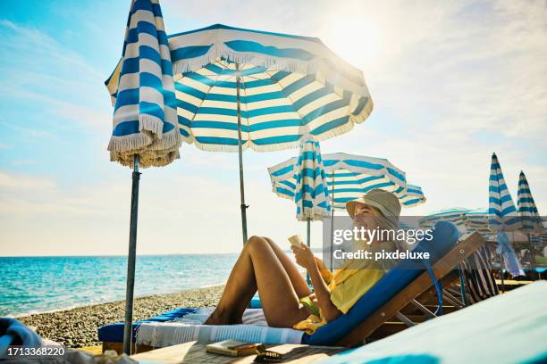 junge erwachsene frau, die sich im urlaub an der côte d'azur, frankreich, in einem luxushotel entspannt. - beach umbrella sand stock-fotos und bilder