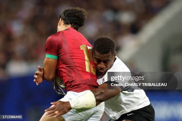 Portugal's full-back Manuel Cardoso Pinto is tackled by Fiji's inside centre Josua Tuisova during the France 2023 Rugby World Cup Pool C match...