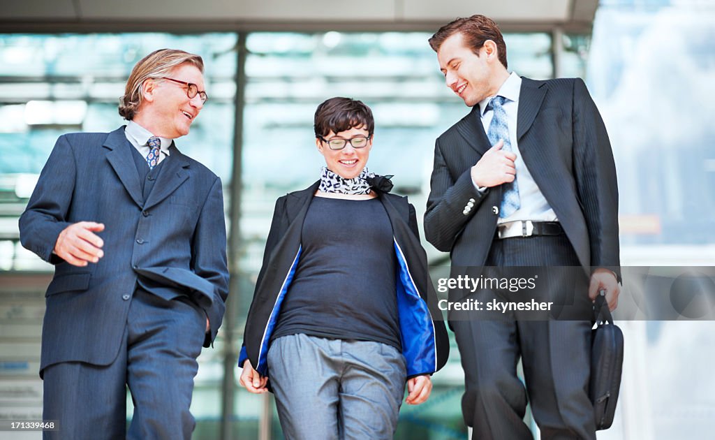 Smiling business people walking down the stairs.