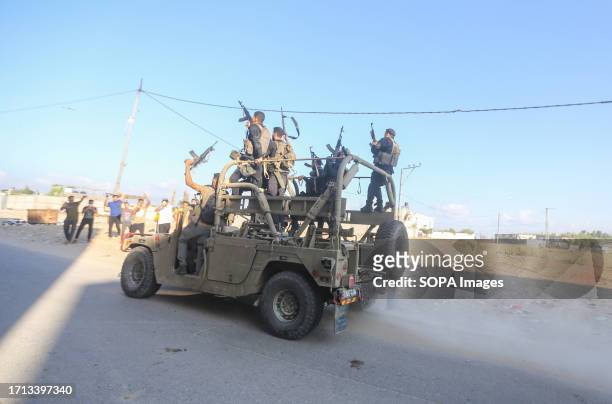Palestinian militants drive an Israeli military vehicle that was seized by gunmen who infiltrated areas of southern Israel, in the northern Gaza...
