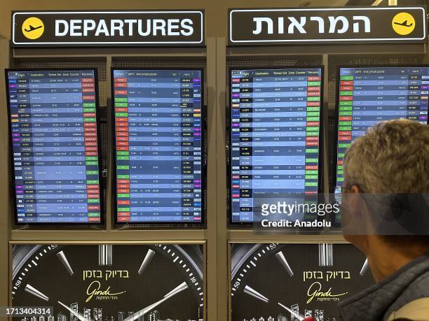 Man looks at the board showing departure schedules at Ben Gurion Airport, Israel's only international airport, after many flights from abroad are...