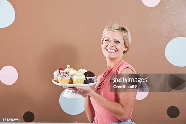 mujer agarrando placa de cupcakes - cupcake holder fotografías e imágenes de stock
