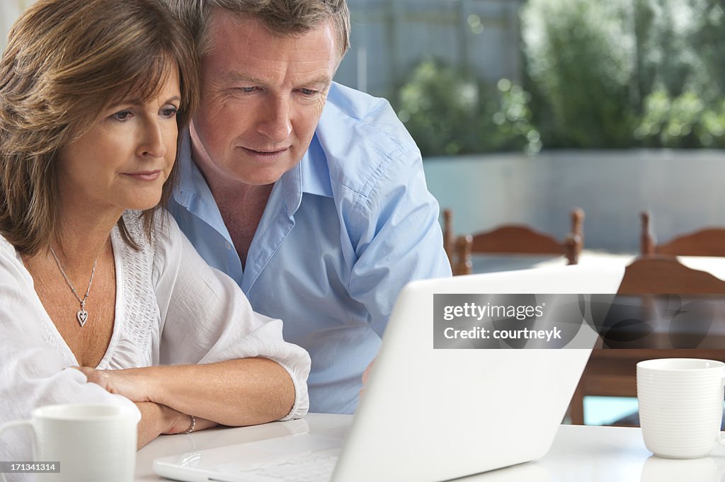 Worried mature couple using wireless technology