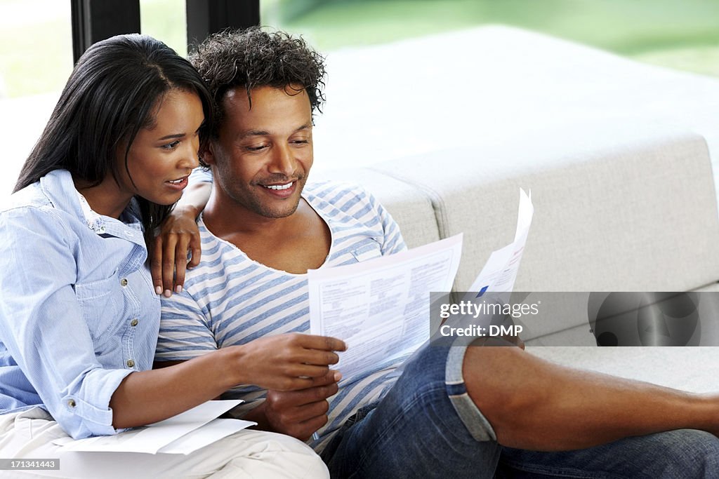 Young couple reading financial bill at home