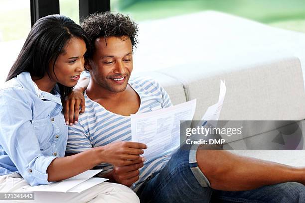 young couple reading financial bill at home - bank statement stock pictures, royalty-free photos & images