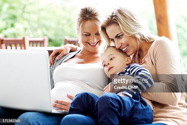 cute little family looking at laptop - cute lesbian couples 個照片及圖片檔