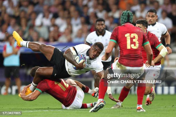 Fiji's wing Josua Tuisova is tackled by Portugal's inside centre Jose Lima during the France 2023 Rugby World Cup Pool C match between Fiji and...