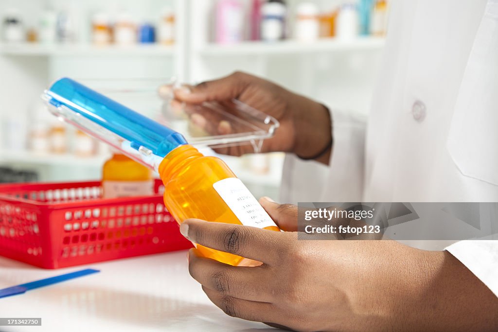 Pharmacist filling bottle for a prescription