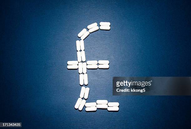 pound sign illustrated with white pills on blue background - sterling stock pictures, royalty-free photos & images