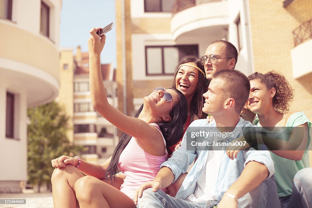 Group of young people taking picture with mobile phone outdoors