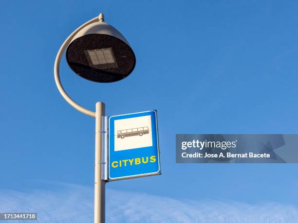 modern street lamp with led panel bulb and a bus stop plate. - led street light stock pictures, royalty-free photos & images