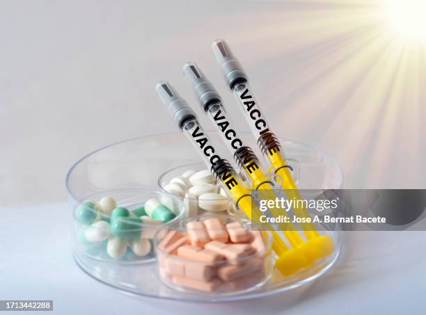 syringes with vaccines for covid 19 and a box with medications for your symptoms. - viral shedding stock-fotos und bilder