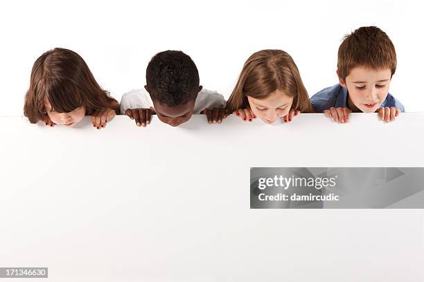 group of multi ethnic children holding a white board - kids placard stock pictures, royalty-free photos & images