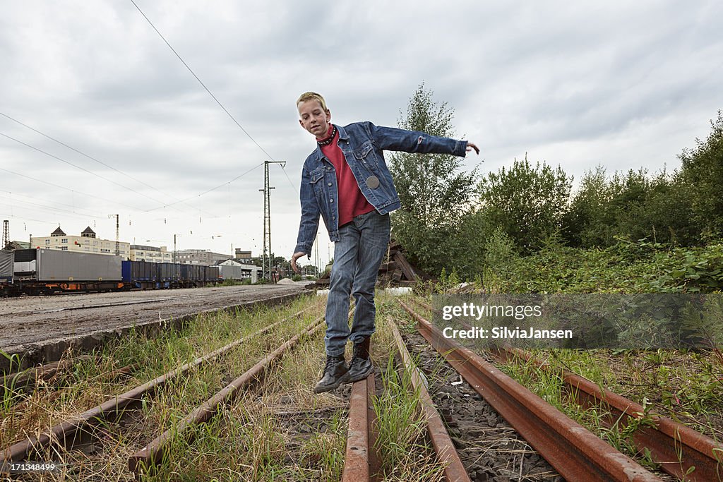 Adolescente in equilibrio su ferrovia