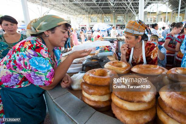 two women chatting on food stand - uzbekistan market stock pictures, royalty-free photos & images