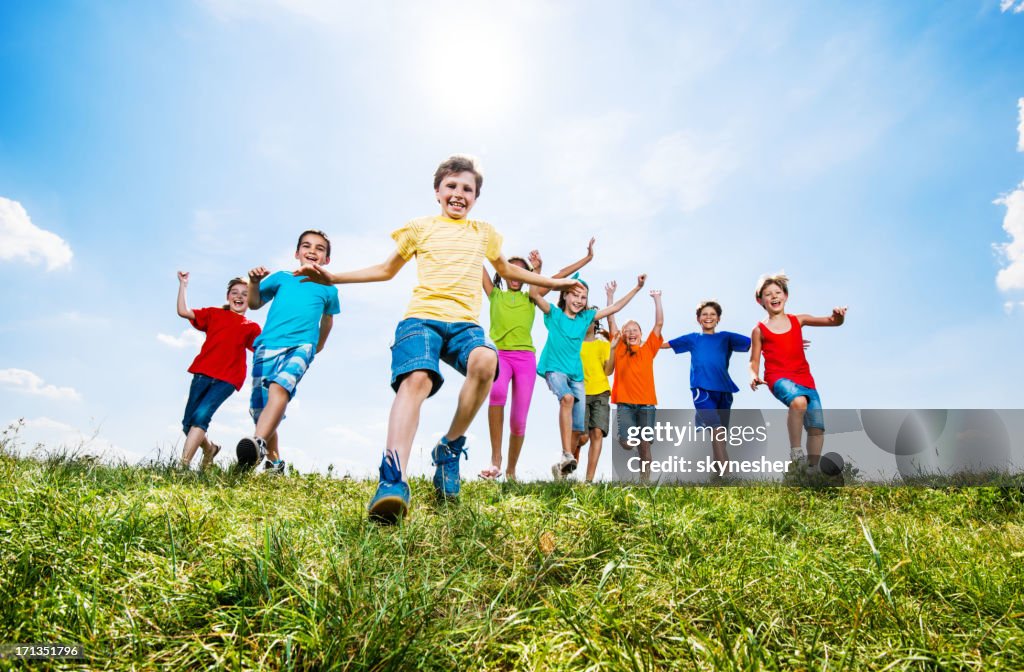 Cheerful kids running in the field.