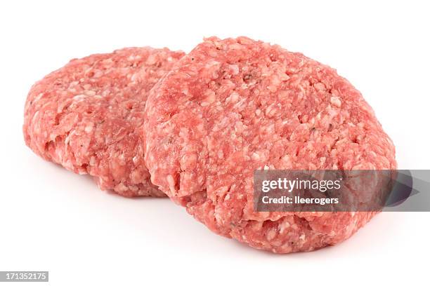 two delicious angus beef burgers isolated on a white background - raw stock pictures, royalty-free photos & images