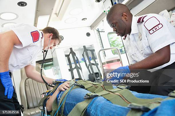 ambulanza medics aiutando una lesione ragazza in modo da ospedale - restraining device foto e immagini stock