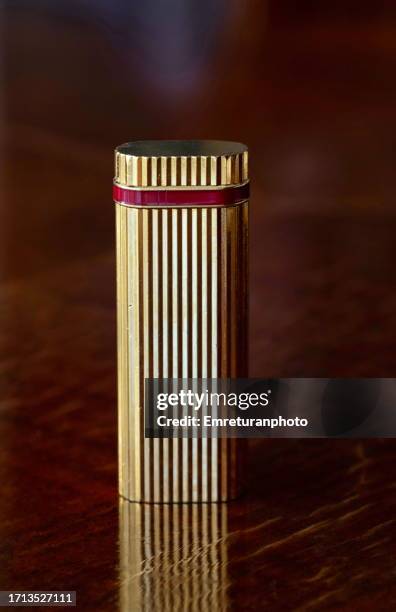 front view of a gold lighter on a wooden table. - premium lighter stock pictures, royalty-free photos & images