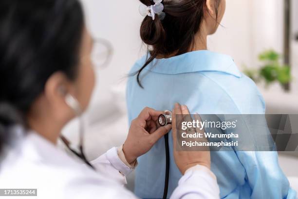 doctor uses stethoscope to listen to the lungs of a female asian patient to determine symptoms and provide treatment. - lunga bildbanksfoton och bilder