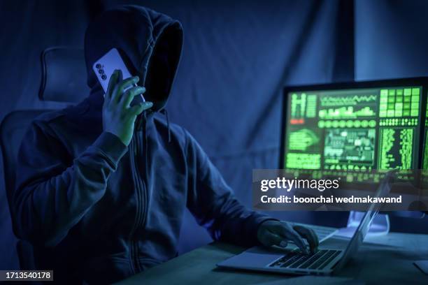computer hacker using phone. - criminal stock pictures, royalty-free photos & images