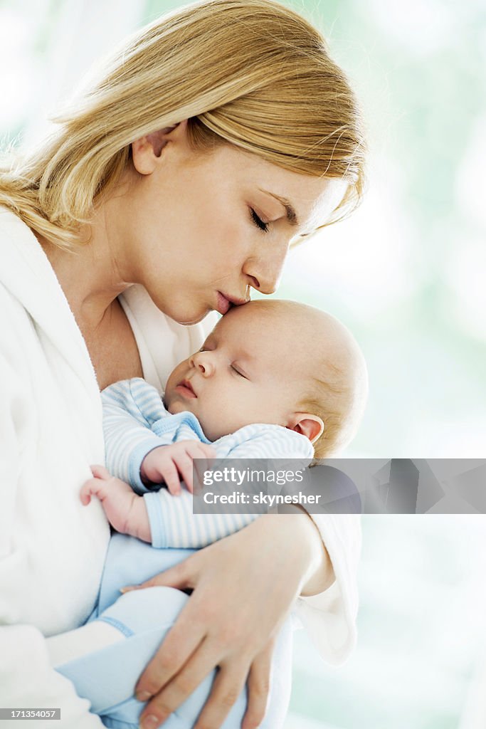 Mother holding her sleeping baby boy.