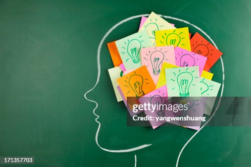 Head on chalkboard with light bulb notes inside Head on chalkboard with light bulb notes inside