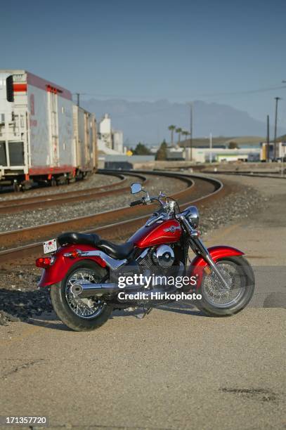 motorcycle parked near train tracks - kawasaki stockfoto's en -beelden