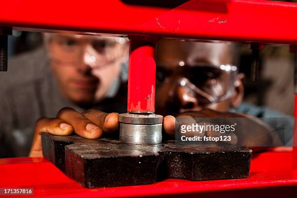 two workmen using a hydraulic press in workshop - pushing stock pictures, royalty-free photos & images
