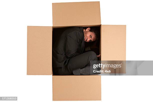homme d'affaires à l'intérieur d'une boîte en carton - contorsioniste photos et images de collection