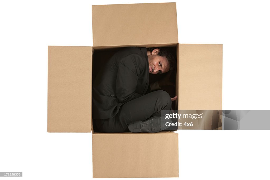 Empresário no interior de uma caixa de cartão