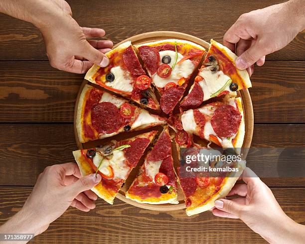 hands holding pizza slices - generosity bildbanksfoton och bilder