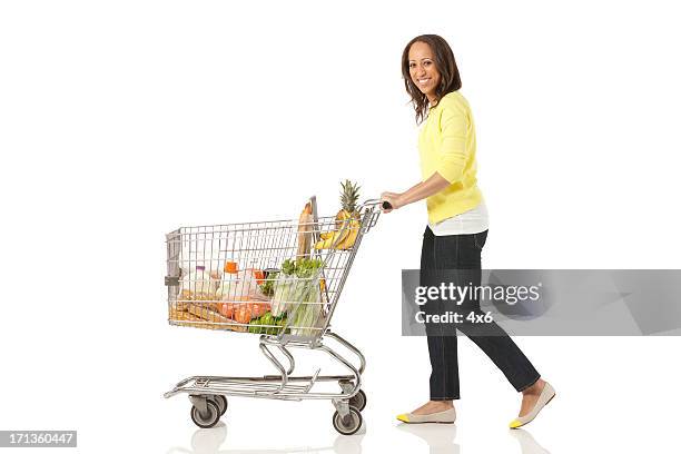 donna spingendo il carrello degli acquisti - spingere carrello foto e immagini stock