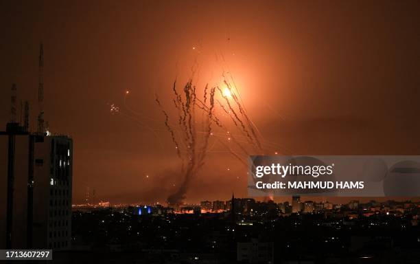 Salvo of rockets is fired by Palestinian militants from Gaza as an Israeli missile launched from the Iron Dome defence missile system attempts to...