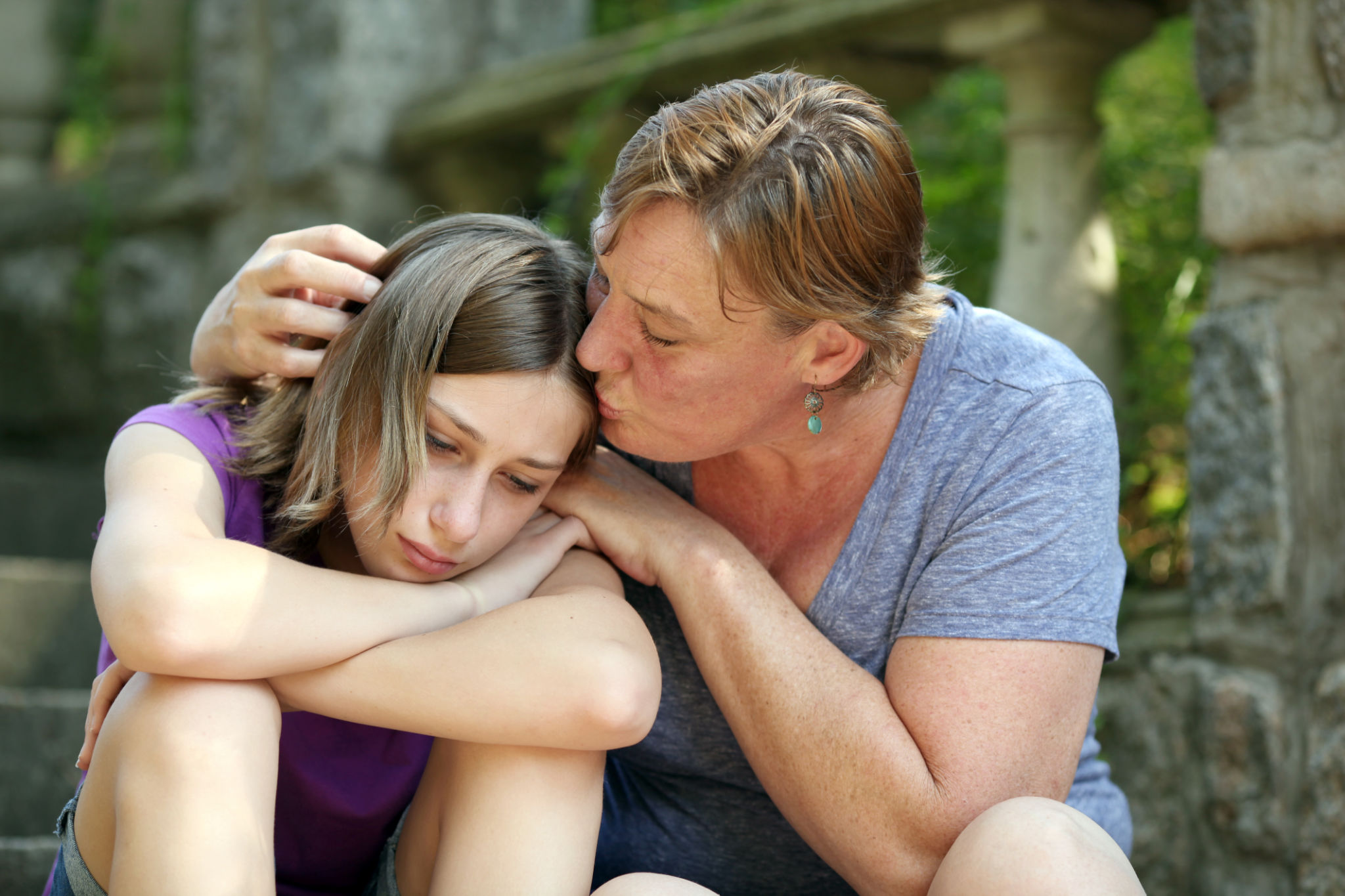 Mother consoles daughter with a kiss. Mother consoles daughter with a kiss.