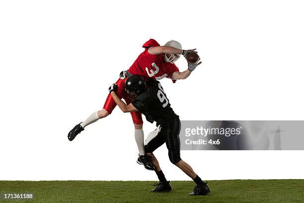 two american football players in action - tackling stockfoto's en -beelden