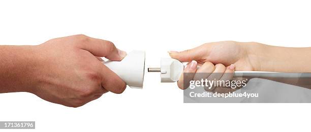 man and woman hands holding european plug and outlet isolated - plug in stock pictures, royalty-free photos & images